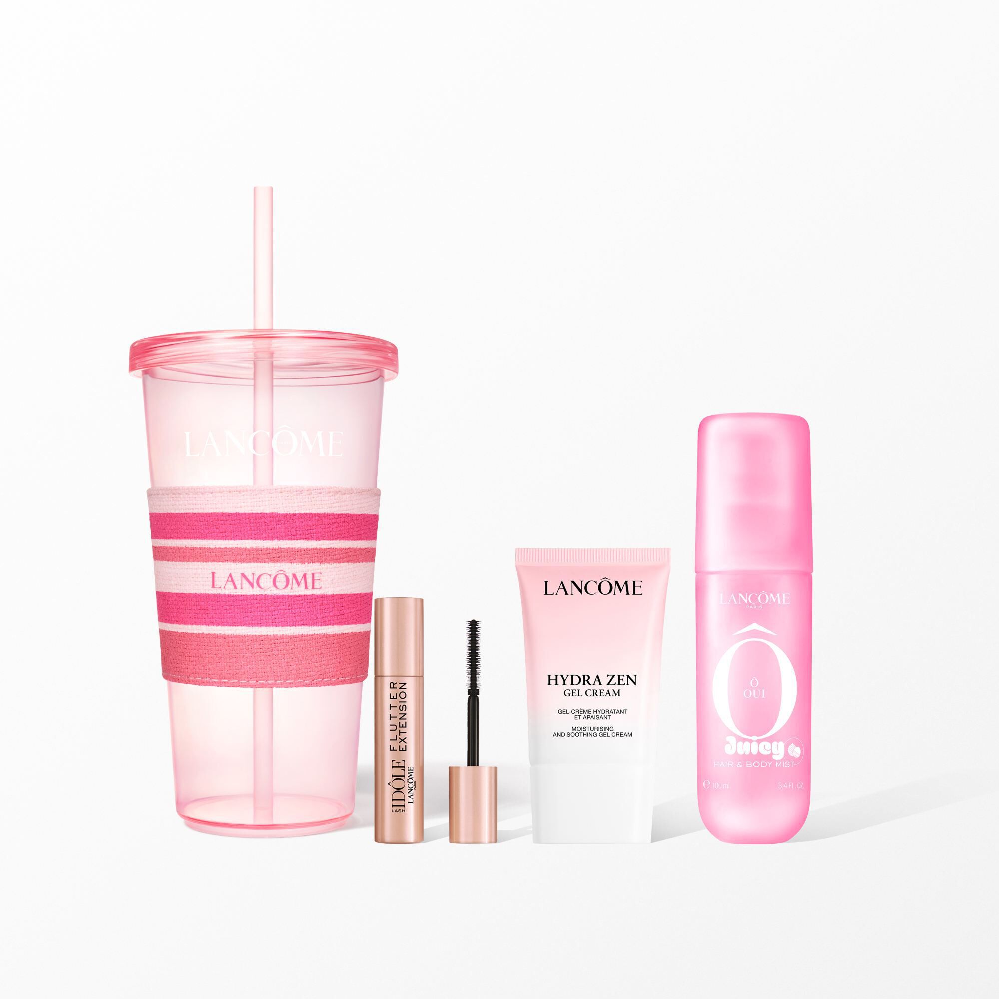 Un set de belleza Lancome con un vaso rosa reutilizable con una faja de rosas, mascara, crema facial y una nube rosa para el pelo y el cuerpo.