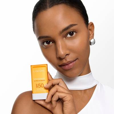 MODELO QUE SOSTIENE EL SUPER SCREEN SUN STICK a la altura del hombro