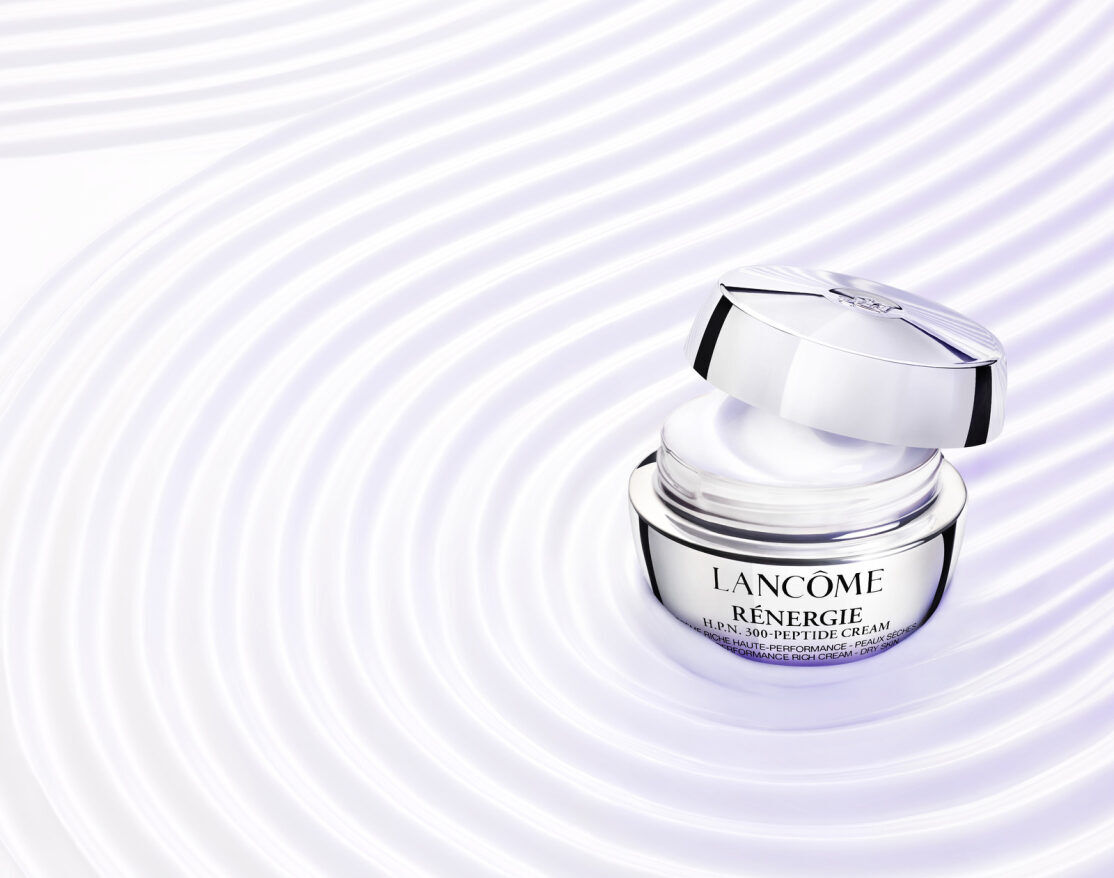 Crema de lujo Lancome Renergie H.P.N. 300-Peptide, presentada en un frasco abierto, con un fondo de ondas suaves.