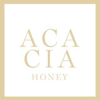 Texto alternativo: Logotipo de "Acacia Honey" con letras doradas sobre un fondo blanco.