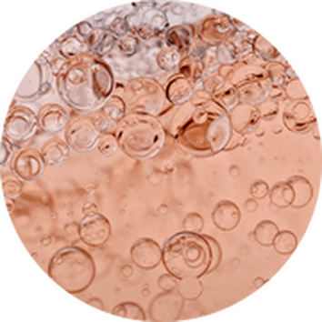 Burbujas de aire flotando en un liquido rosa claro, creando un efecto fresco y dinamico.