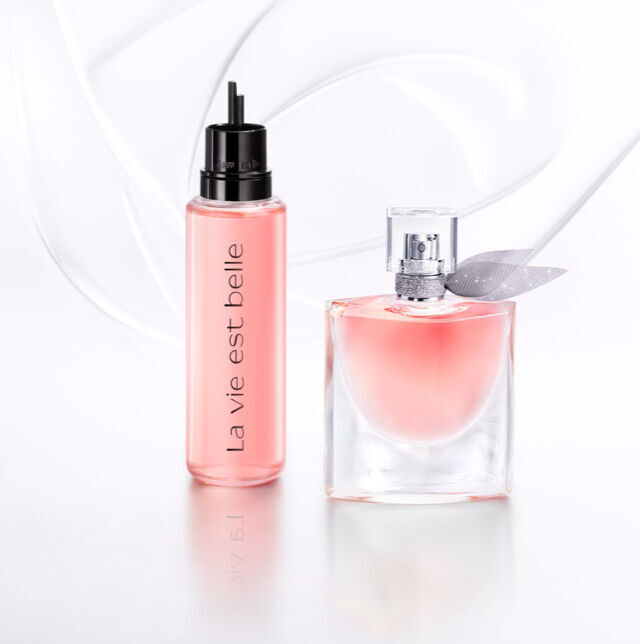 Frascos de perfume con etiquetas elegantes sobre un fondo claro y suave.
