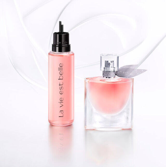 Frascos de perfume con etiquetas elegantes sobre un fondo claro y suave.
