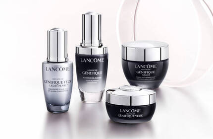 Cuatro frascos de productos de cuidado de la piel de la marca Lancome sobre un fondo claro.