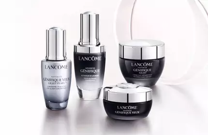 Cuatro frascos de productos de cuidado de la piel de la marca Lancome sobre un fondo claro.