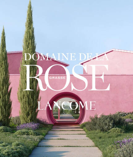 Fachada pink de un edificio moderno rodeado de naturaleza, con las palabras "Domaine de la Rose Lancome" en el frente.
