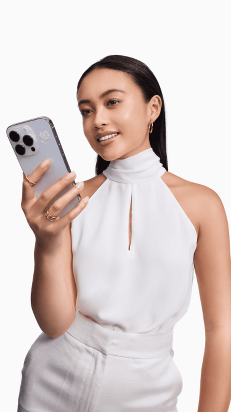 Una mujer sostiene un telefono movil con el logotipo de una rosa de Lancome